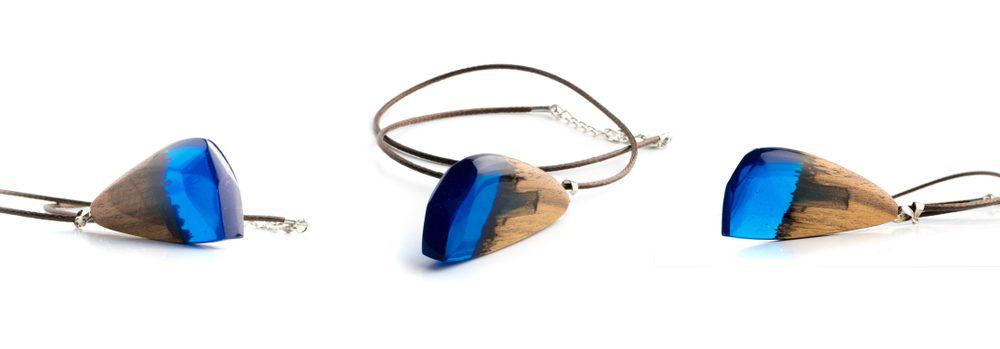 Tear drop shape blue epoxy and resin and wood  attached to a black leather necklace. 