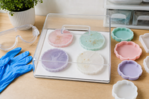 Beginner epoxy resin safety workspace with gloves, goggles, measuring cups, and silicone molds.