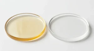 Side-by-side comparison of a yellowed amber resin coaster next to a clear, colorless resin coaster