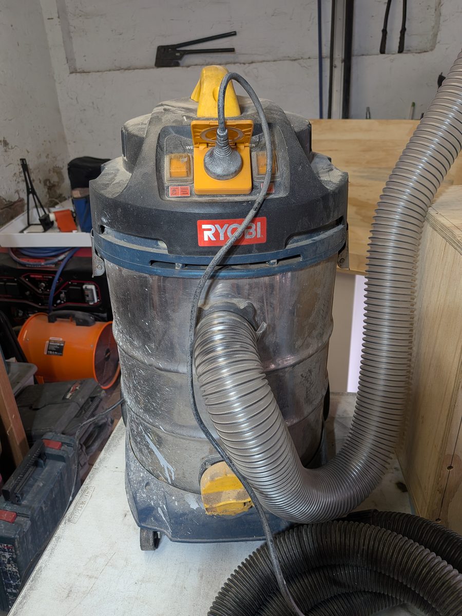 Roughly 15-year-old Ryobi wet and dry shop vac with a tool plugged into its auto-start power socket