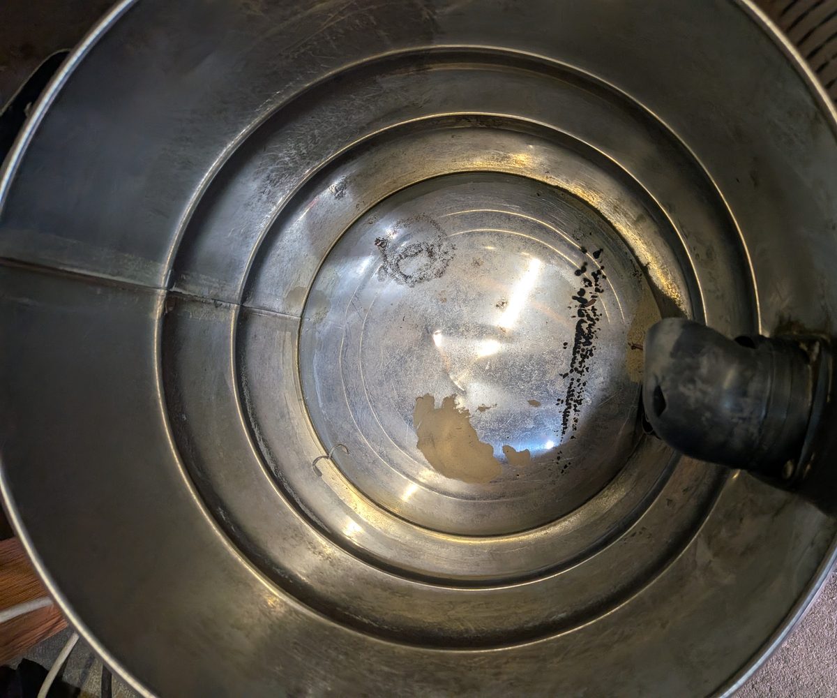 Inside of the shop vac drum after use with the cyclone fitted, almost empty with only a few specks of dust