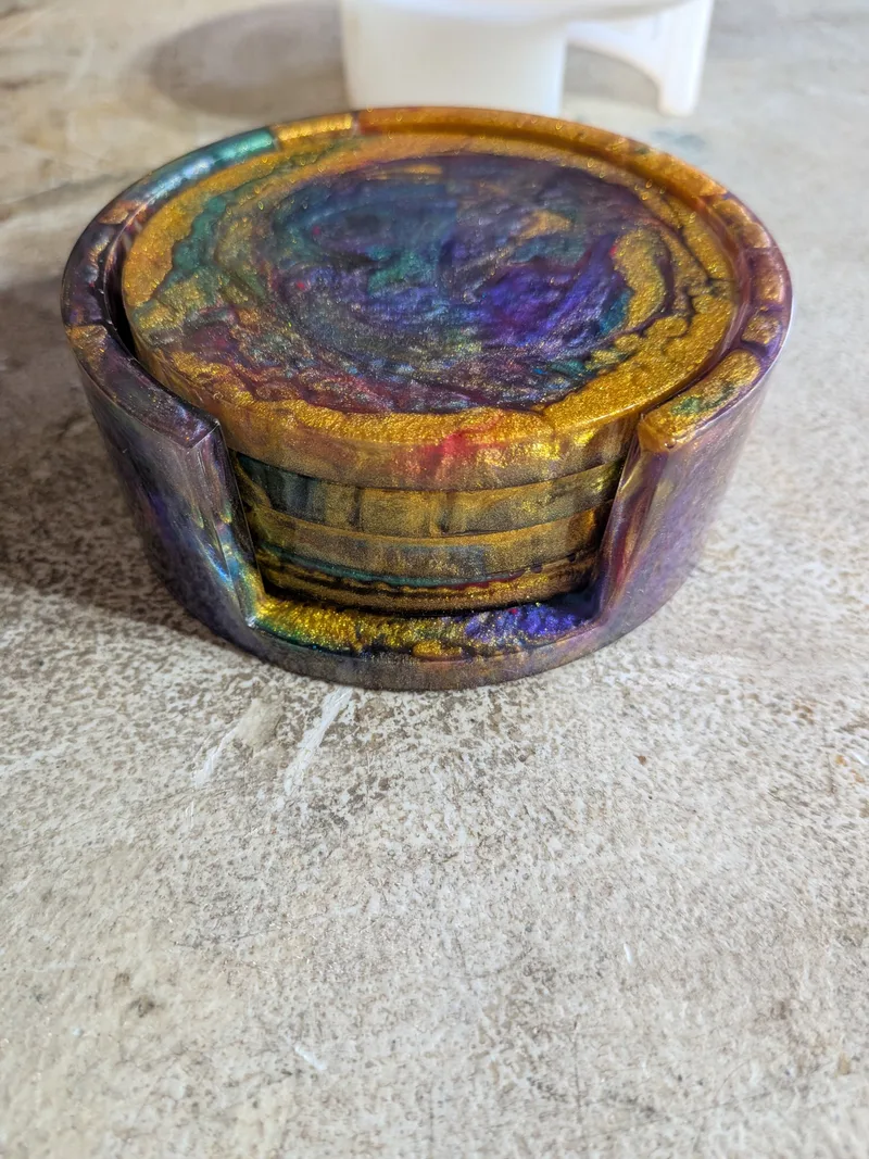 Four purple and gold epoxy resin coasters stacked in a matching round resin coaster holder