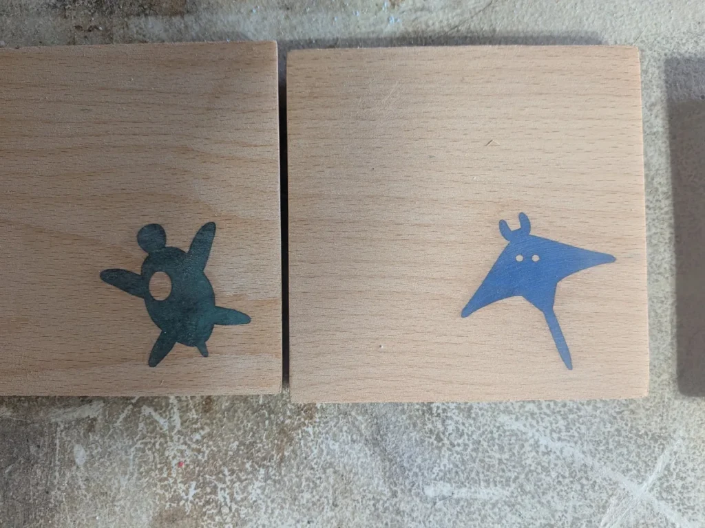 Resin fills sanded flush and matte in two beech coasters, with the darkened halo gone