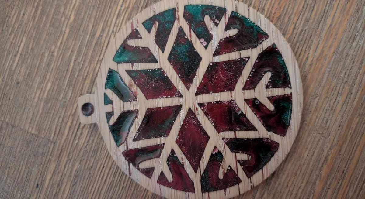 Sanded wood and resin ornament showing small white dots where sanding opened bubbles